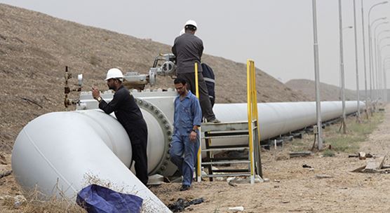 Adjusting a valve of an oil pipe in Iraq. Growth among oil exporters in the Middle East, North Africa, Afghanistan, and Pakistan remains subdued due to low oil prices (photo: Stringer/Iraq/REUTERS/Newscom)