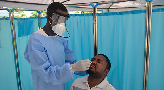 A medical worker tests for the COVID-19 virus in Uganda. The health pandemic hit the country  hard and was partly responsible for the halving of its real GDP growth. (Photo: Nicholas Kajoba/Xinhua/Newscom)