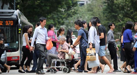 Pejalan kaki menyeberangi jalanan sibuk di Singapura: negara-negara ASEAN, termasuk Singapura, terus menghasilkan pertumbuhan yang kuat, sebagaimana dinyatakan laporan regional terbaru IMF (photo: Calvin Wong/Newscom)