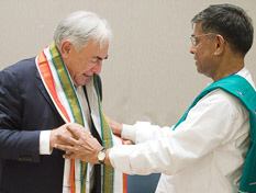 P. Changal Reddy, Secretario General del Consorcio de asociaciones de granjeros indios, entrega un chal a Dominique Strauss-Kahn en nombre de la comunidad granjera.