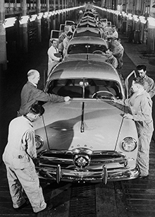 Workers put the finishing touches on a 1949 Ford sedan.